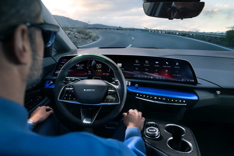 Front View of the 2026 OPTIQ-V Driving Through the Dusk Utilizing its Headlights | Faulkner Cadillac Mechanicsburg in mechanicsburg PA